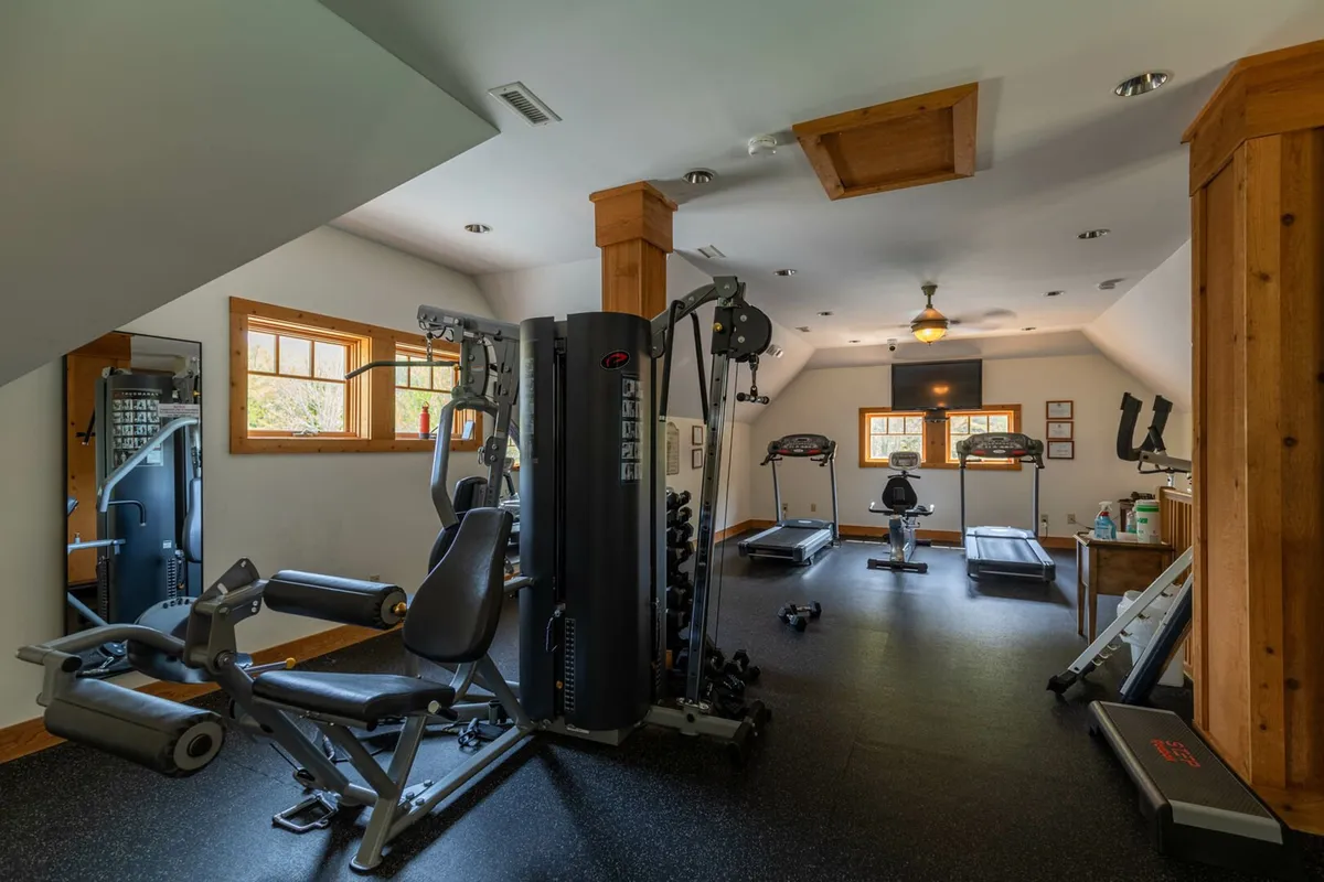 A well-equipped fitness center featuring treadmills, multi-gym stations, free weights, and large windows that flood the room with natural light. The space feels energizing and motivating, perfect for guests looking to maintain their workout routine while away.